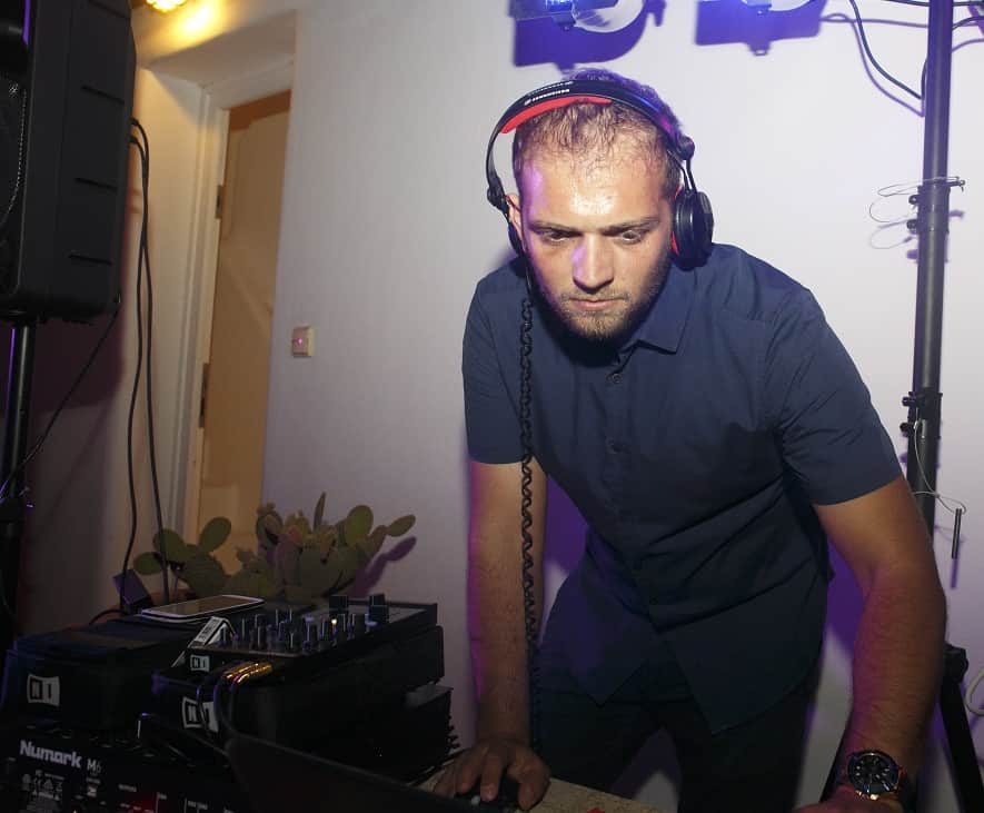 DJ in headphones at the decks during Jelly and Kostas's wedding reception
