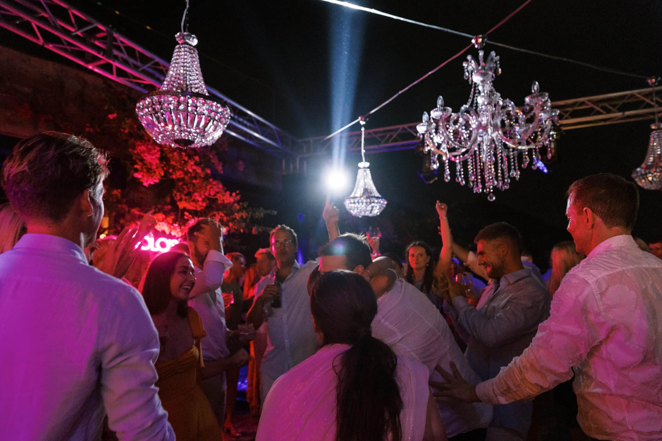 Dance floor under crystal chandeliers and moving-head beams at Liz and Josh's Mykonos wedding